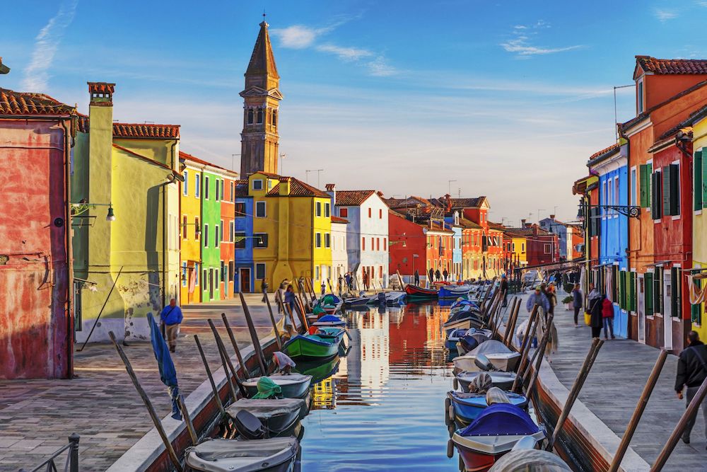 A canal cuts through a neighborhood with colorful buildings on each side.